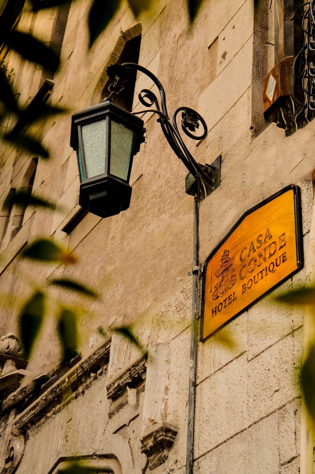 Cartel de madera de Casa Conde Hotel Boutique junto al farol de la calle